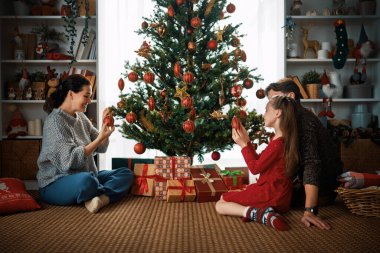Mutlu Noeller, mutlu tatiller. Anne, baba ve kızı ağacın içinde. Noel 'den önceki sabah. 