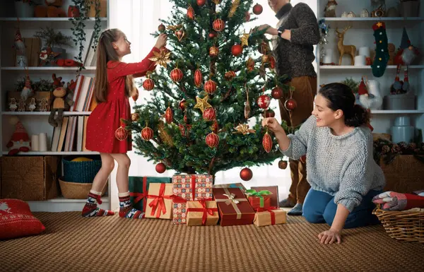 Mutlu Noeller, mutlu tatiller. Anne, baba ve kızı ağacın içinde. Noel 'den önceki sabah. 