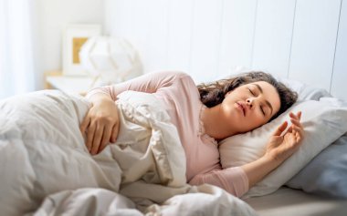 Güzel genç bir kadın evdeki yatak odasında uyuyor..