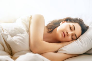 Güzel genç bir kadın evdeki yatak odasında uyuyor..