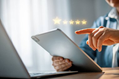 Derecelendirme başvurusu için elinde bir tablet var.
