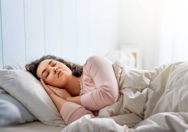 Güzel genç bir kadın evdeki yatak odasında uyuyor..
