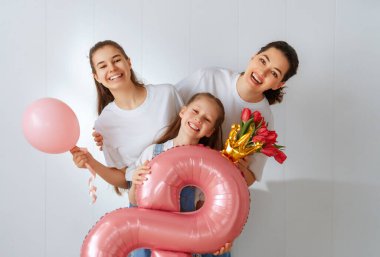 Mutlu bir gün. Çocuklar annelerini kutluyor ve ona çiçek veriyorlar. Aile tatili ve birliktelik. Uluslararası Kadın Günü kavramı.