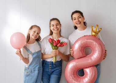 Mutlu bir gün. Çocuklar annelerini kutluyor ve ona çiçek veriyorlar. Aile tatili ve birliktelik. Uluslararası Kadın Günü kavramı.