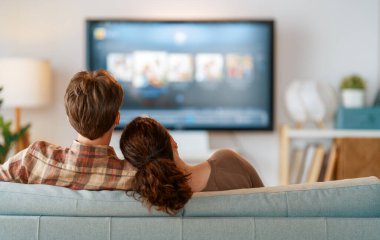 Mutlu bir aile televizyon seyrediyor, akşamları evde film seyrediyor. Çiftler birlikte vakit geçiriyorlar..