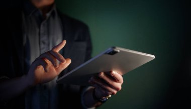 Adam tablet bilgisayar kullanıyor. Bilgisayar ve eller kapalı..