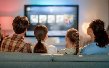 Mutlu aile birlikte vakit geçiriyor. Anne, baba ve çocuklar televizyon izliyor, akşamları evde patlamış mısırlı filmler izliyorlar..