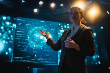 Sahnede bir kadın yapay zeka teknolojilerinin geleceği hakkında konuşuyor..