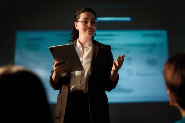 Sahnede bir kadın yapay zeka teknolojilerinin geleceği hakkında konuşuyor..