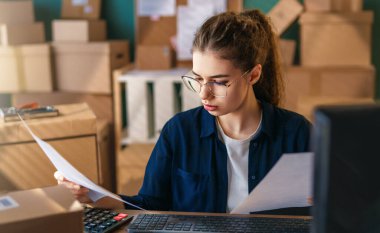 Kadın envanter müdürü stokları kontrol ediyor. Depoda çalışan bir kadın.. 