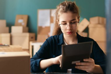 Kadın envanter müdürü stokları kontrol ediyor. Depoda çalışan bir kadın.. 