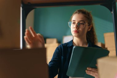 Kadın envanter müdürü stokları kontrol ediyor. Depoda çalışan bir kadın.. 