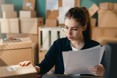 Kadın envanter müdürü stokları kontrol ediyor. Depoda çalışan bir kadın.. 