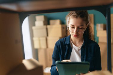 Kadın envanter müdürü stokları kontrol ediyor. Depoda çalışan bir kadın.. 