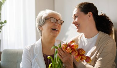 Güzel genç bir kadın ve elinde çiçeklerle annesi ellerinde laleler..  