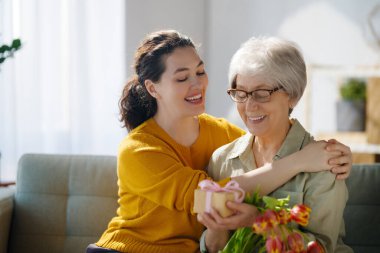 Güzel genç bir kadın ve elinde çiçeklerle annesi ellerinde laleler..  