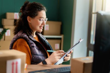 Kadın envanter müdürü stokları kontrol ediyor. Depoda çalışan bir kadın.. 