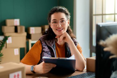 Kadın envanter müdürü stokları kontrol ediyor. Depoda çalışan bir kadın.. 