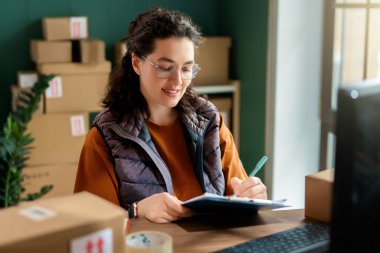 Kadın envanter müdürü stokları kontrol ediyor. Depoda çalışan bir kadın.. 