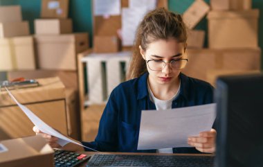 Kadın envanter müdürü stokları kontrol ediyor. Depoda çalışan bir kadın.. 