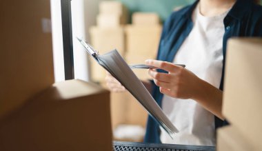 Kadın envanter müdürü stokları kontrol ediyor. Depoda çalışan bir kadın..