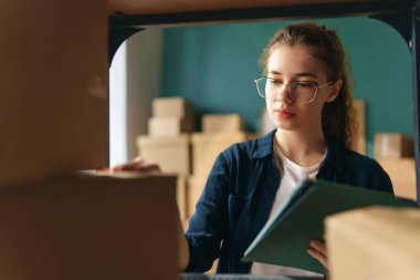 Kadın envanter müdürü stokları kontrol ediyor. Depoda çalışan bir kadın.. 