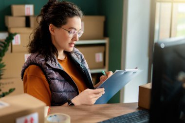 Kadın envanter müdürü stokları kontrol ediyor. Depoda çalışan bir kadın.. 