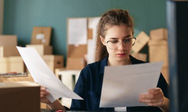 Kadın envanter müdürü stokları kontrol ediyor. Depoda çalışan bir kadın.. 