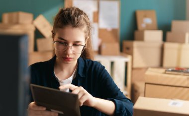 Kadın envanter müdürü stokları kontrol ediyor. Depoda çalışan bir kadın.. 