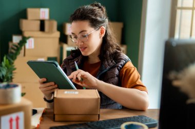 Kadın envanter müdürü stokları kontrol ediyor. Depoda çalışan bir kadın.. 