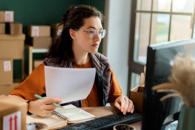Kadın envanter müdürü stokları kontrol ediyor. Depoda çalışan bir kadın.. 