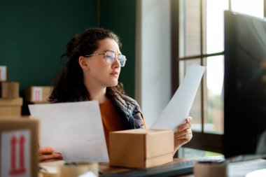 Kadın envanter müdürü stokları kontrol ediyor. Depoda çalışan bir kadın.. 