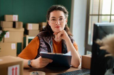 Kadın envanter müdürü stokları kontrol ediyor. Depoda çalışan bir kadın.. 