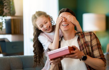 Çocuk kızı babasını tebrik ediyor ve ona bir hediye veriyor. Aile tatili ve birliktelik.