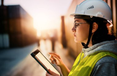 Beyaz şapkalı kadın endüstriyel mühendis konteyner terminalinde çalışıyor..