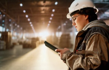 Beyaz şapkalı genç kadın depoda çalışıyor.