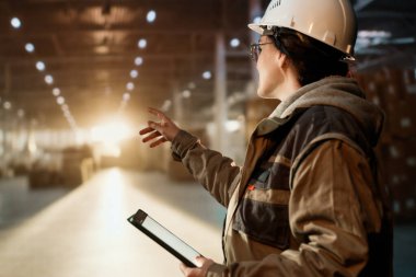 Beyaz şapkalı genç kadın depoda çalışıyor.