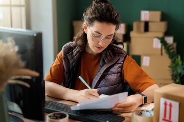 Kadın envanter müdürü stokları kontrol ediyor. Depoda çalışan bir kadın.. 