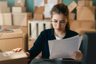 Kadın envanter müdürü stokları kontrol ediyor. Depoda çalışan bir kadın.. 