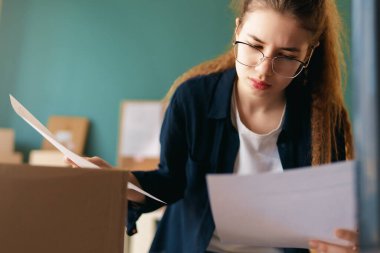 Kadın envanter müdürü stokları kontrol ediyor. Depoda çalışan bir kadın.. 