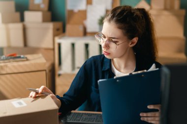 Kadın envanter müdürü stokları kontrol ediyor. Depoda çalışan bir kadın.. 