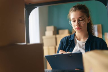Kadın envanter müdürü stokları kontrol ediyor. Depoda çalışan bir kadın.. 