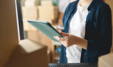 Kadın envanter müdürü stokları kontrol ediyor. Depoda çalışan bir kadın.. 