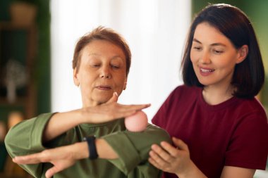 Kıdemli kadın egzersiz yapıyor. Evde fizik tedaviye yardım eden bir hemşire.