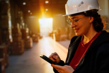 Beyaz şapkalı genç kadın depoda çalışıyor.