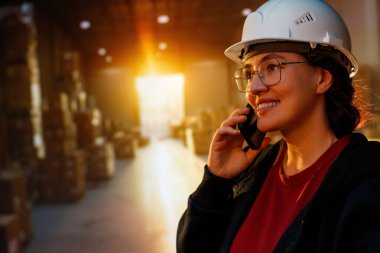 Beyaz şapkalı genç kadın depoda çalışıyor.