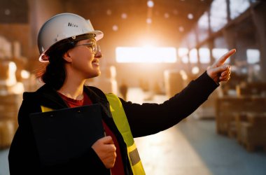 Beyaz şapkalı genç kadın depoda çalışıyor.