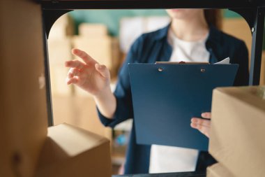 Kadın envanter müdürü stokları kontrol ediyor. Depoda çalışan bir kadın.. 