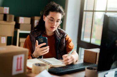 Kadın envanter müdürü stokları kontrol ediyor. Depoda çalışan bir kadın.. 