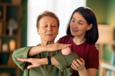 Kıdemli kadın egzersiz yapıyor. Evde fizik tedaviye yardım eden bir hemşire.